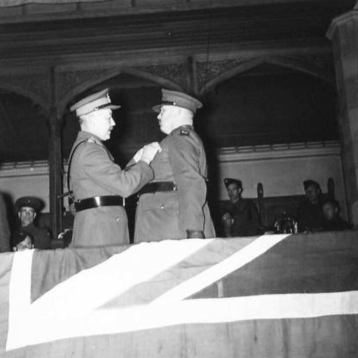 Major General Vivian Henry Bruce Majendie (General Officer Commanding Northern Ireland District) presents the Territorial Decoration to Lieutenant Colonel F.W. Bedford (Officer Commanding The Royal Sussex Regiment) at a church service in the Presbyterian Church's Assembly Buildings, Belfast.