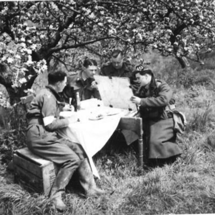 Officers of 2nd Battalion, Royal Inniskilling Fusiliers enjoy an alfresco meal beneath an apple tree in blossom in Northern Ireland.