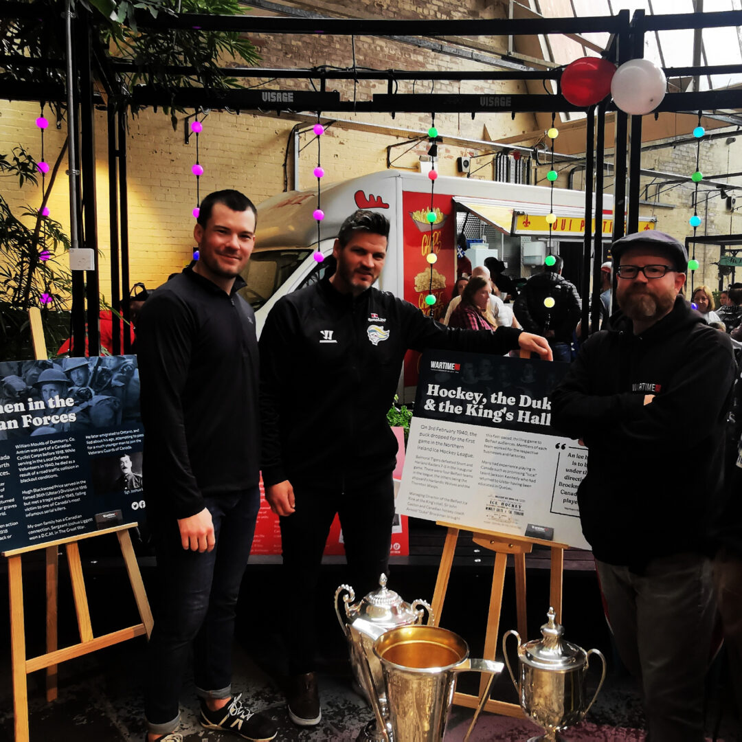 Coach Adam Keefe and Josh Roach of the Belfast Giants learn about the history of Ice Hockey in Northern Ireland at the WartimeNI display during the Canada Day Block Party at Banana Block, Newtownards Road, Belfast.