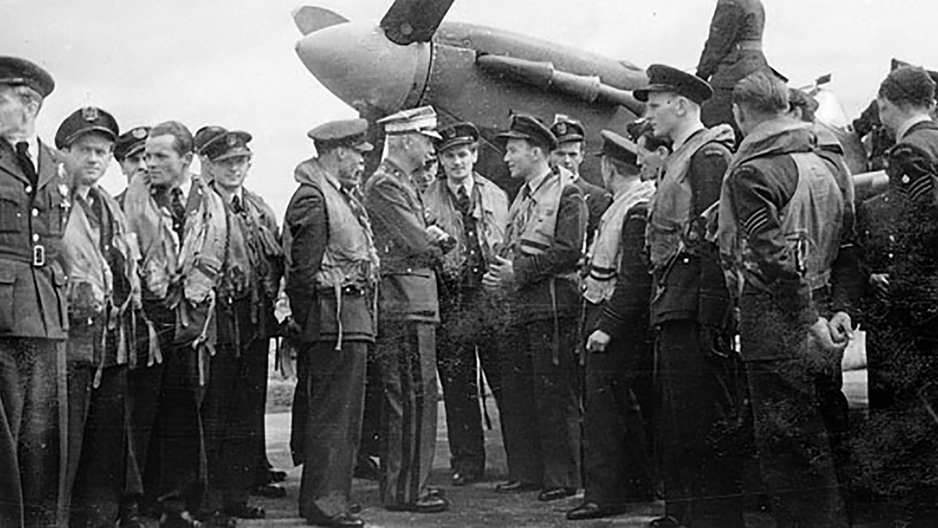 General Sosnkowski in conversation with pilots of R.A.F. 315 (City of Deblin) Squadron who have just staged a flypast at R.A.F. Ballyhalbert, Co. Down. This was a highlight of the Squadron Day celebrations on 14th August 1943. Talking to him is Flight Lieutenant Zajac and Squadron Leader Jerszy Poplawski. In the background is Supermarine Spitfire V BM144 PK-O.