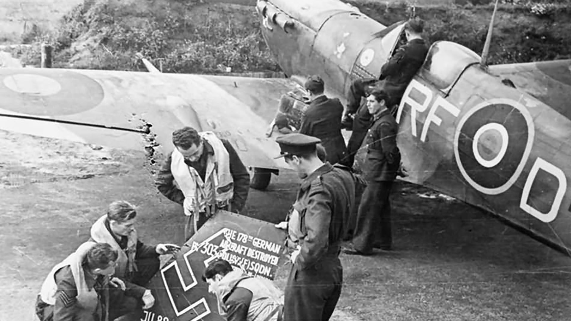 A posed Royal Air Force image showing men from R.A.F. (Kościuszko )303 Squadron marking off the destruction of their 178th enemy plane. This pictured Supermarine Spitfire V BM144 would later crash land near Bangor, Co. Down.