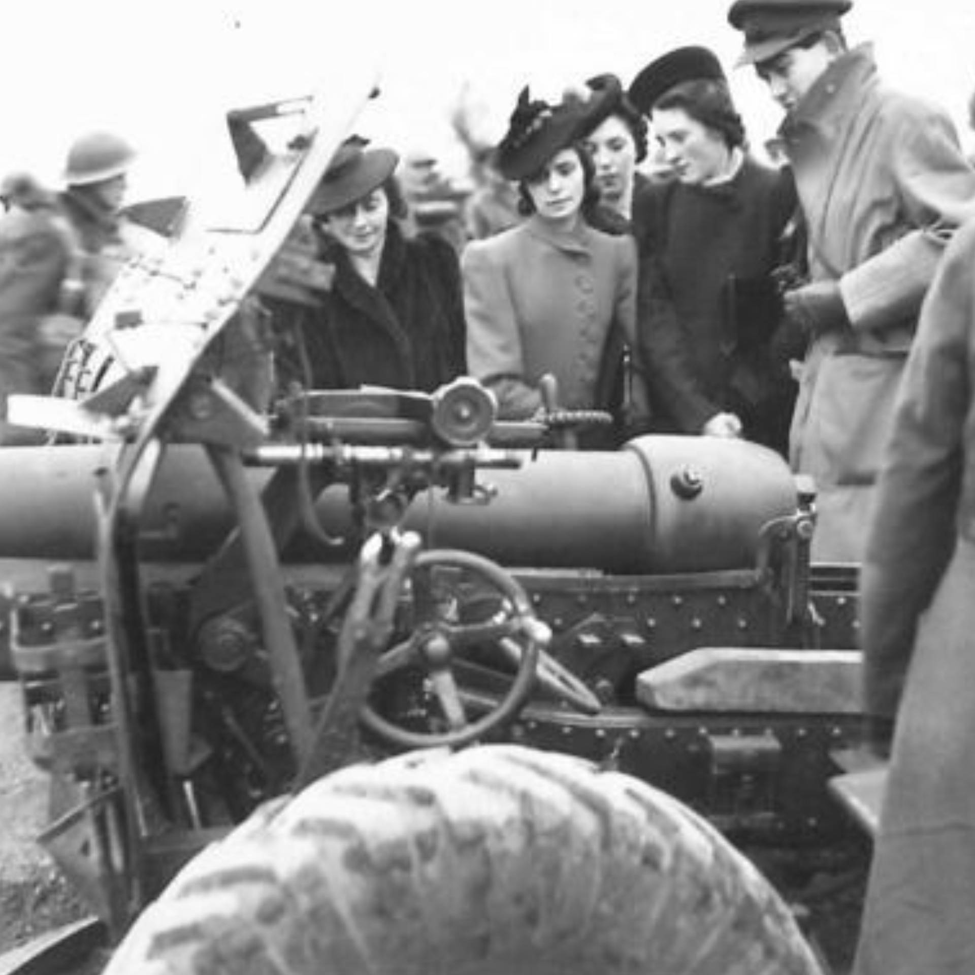 A 5th Divisional Artillery officer shows guns to a group of workers from a munitions factory in Northern Ireland.