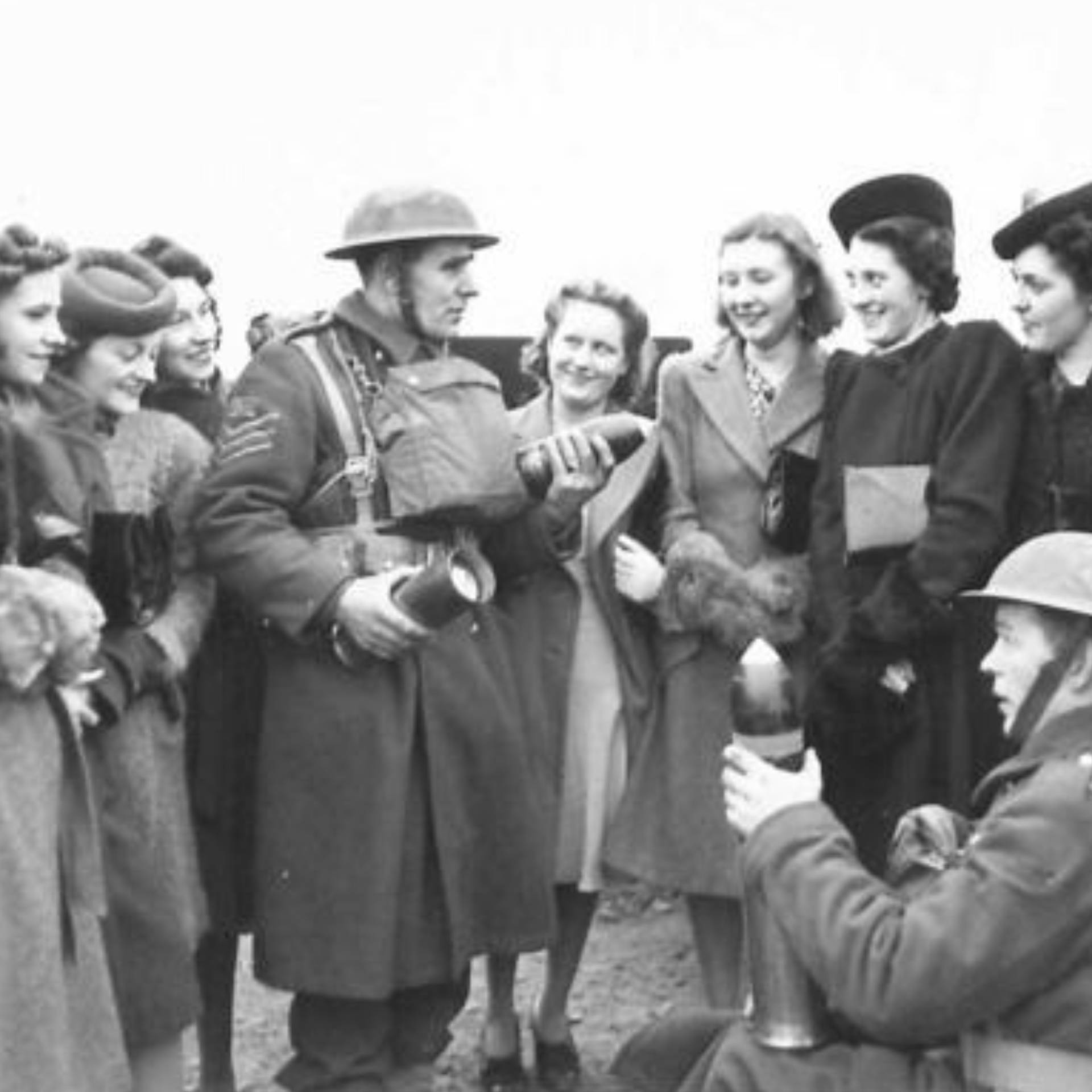 A 5th Divisional Artillery Sergeant shows shells to a group of workers from a munitions factory in Northern Ireland.