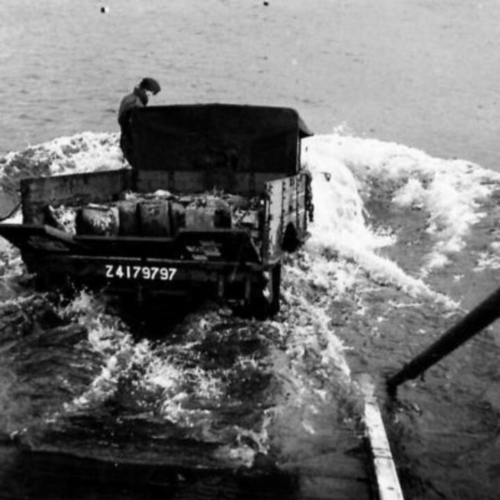 British Army lorry drivers descend a gangway taking their vehicles into the water to test waterproofing.