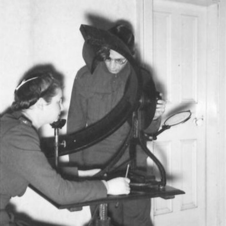 Ophthalmological and Optical Specialists examine a member of the Auxiliary Territorial Service using a perimeter in the minor operating theatre of a Military Ophthalmic Centre at No. 31 (London) General Hospital, Musgrave Park, Belfast.