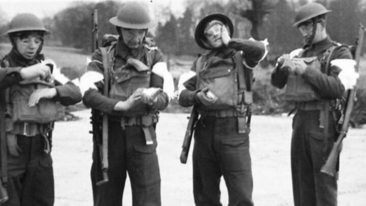 Four soldiers demonstrate the right thing to do during a spray gas attack. These illustrative photographs are from a demonstration held in Northern Ireland.
