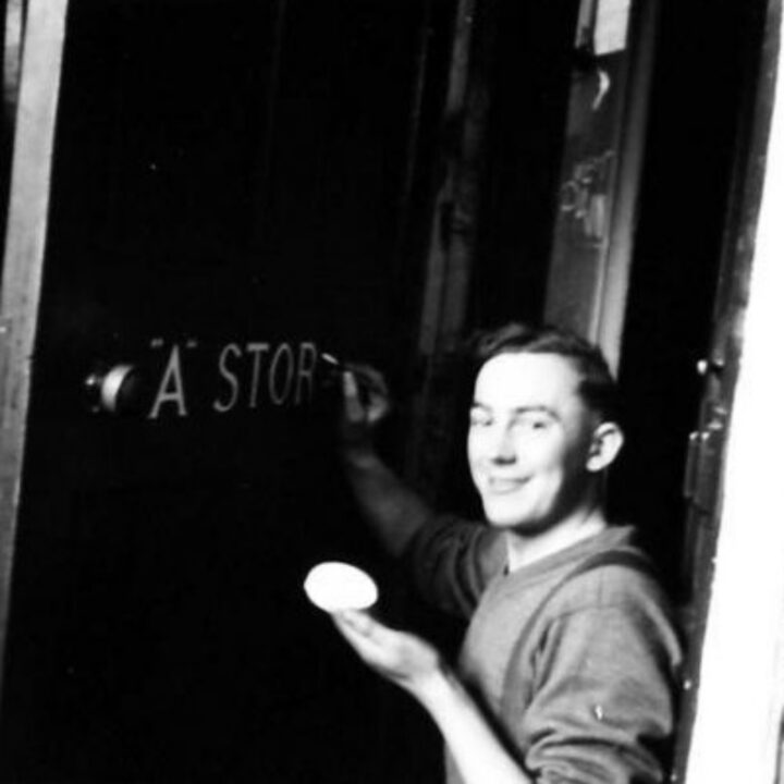 Company Quartermaster Sergeant F. Collins of 2/5th Battalion, Lancashire Fusiliers paints lettering on his store door while training near Keady, Co. Armagh.
