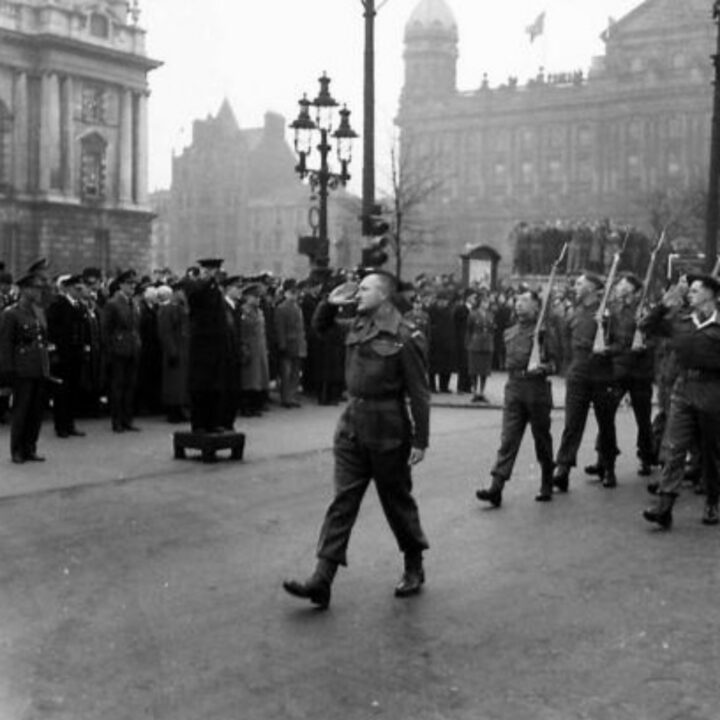 Mr. Albert Victor Alexander (First Lord of the Admiralty) takes the salute from British Army soldiers during a parade marking the 26th anniversary of the Red Army at Belfast City Hall, Belfast.