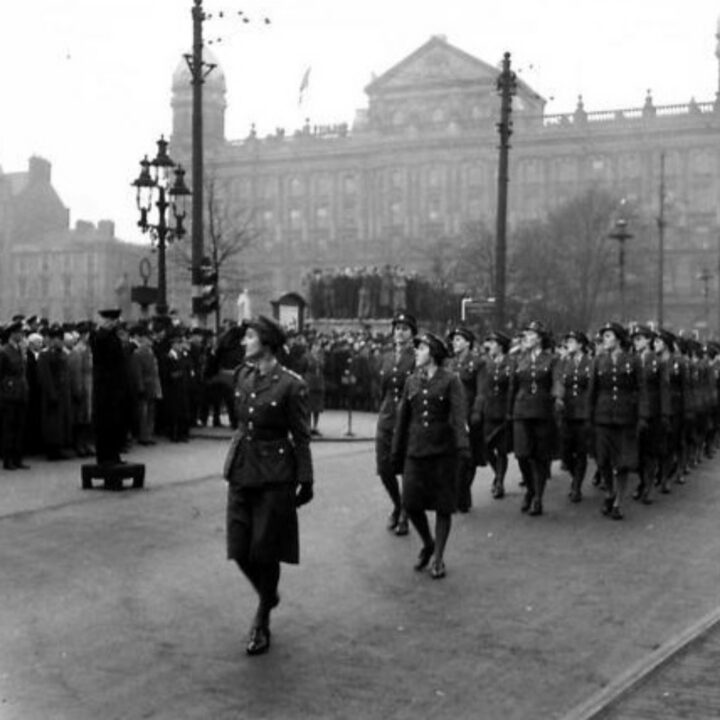 Mr. Albert Victor Alexander (First Lord of the Admiralty) takes the salute from members of the Auxiliary Territorial Service during a parade marking the 26th anniversary of the Red Army at Belfast City Hall, Belfast.